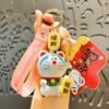 Lucky cat style blue cat keychain with pink strap and red charm tag